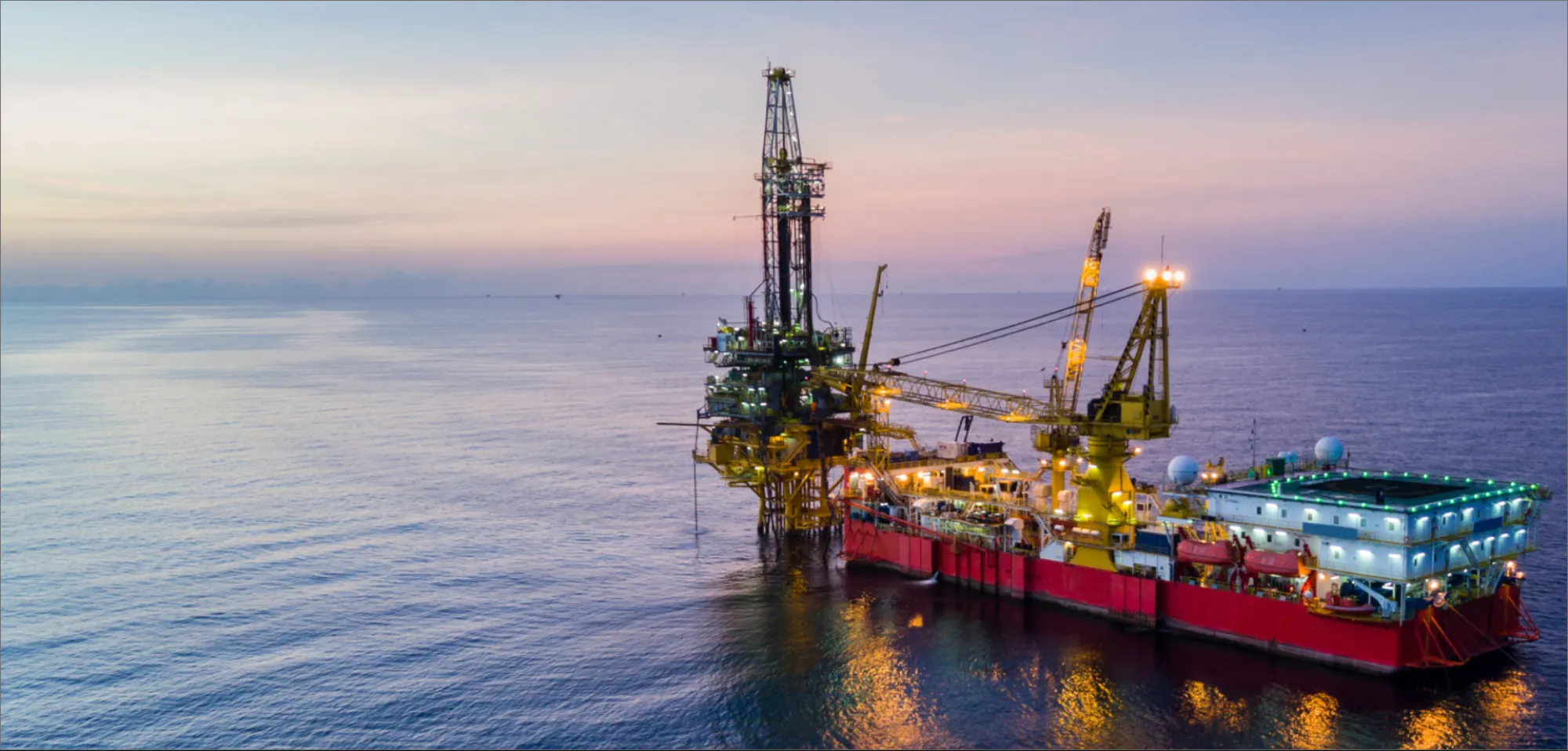 Offshore drilling and construction vessel at dusk